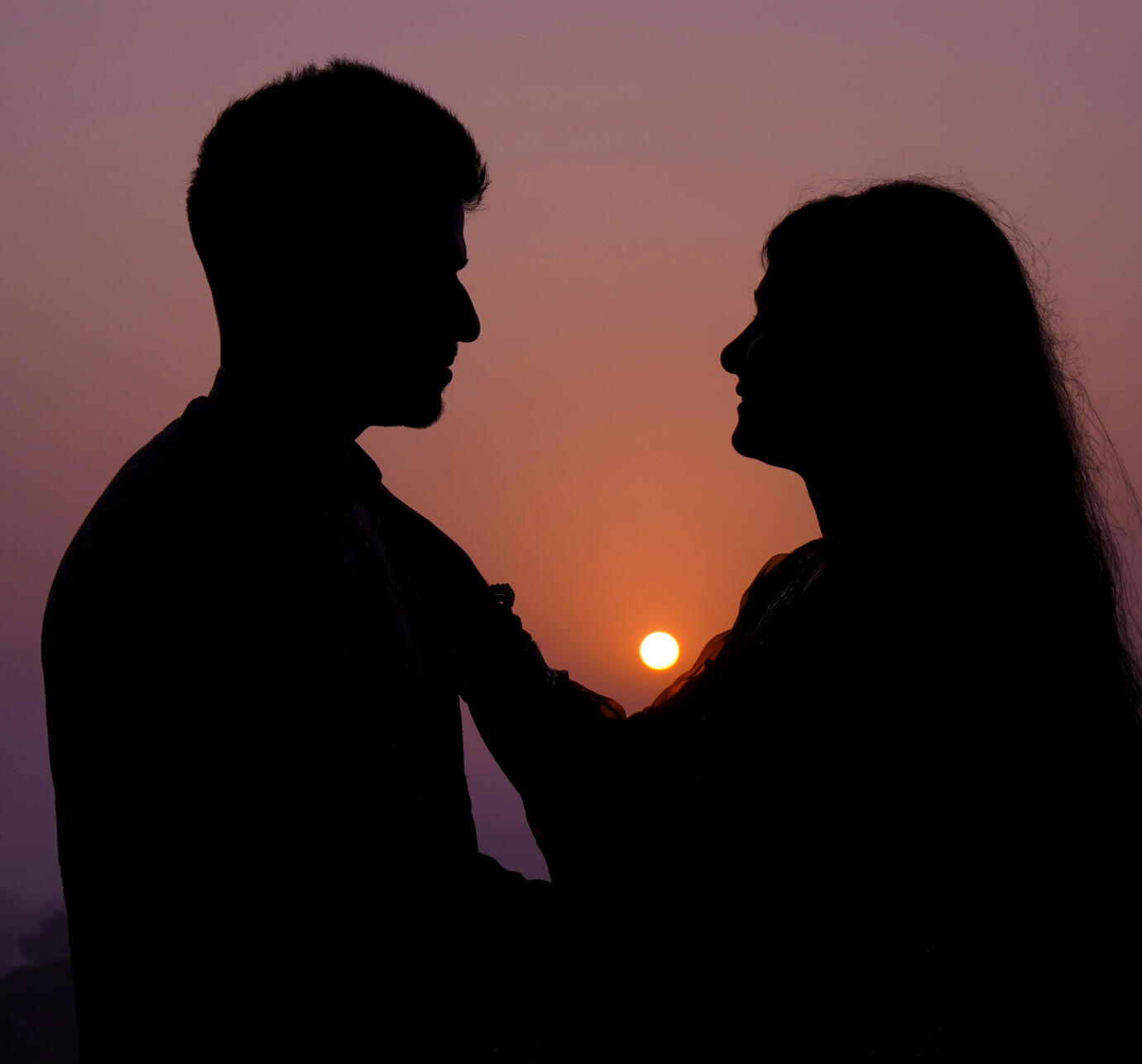 A romantic silhouette of a couple at sunset — symbolizing deep love and personal connection Silhouette of a couple facing each other at sunset, symbolizing love and connection